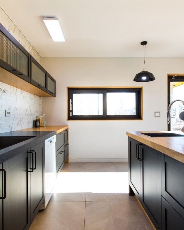 Kitchen with dark lower cabinets and a warm butcher block island, renovated by Elm Kitchen in London, Ontario