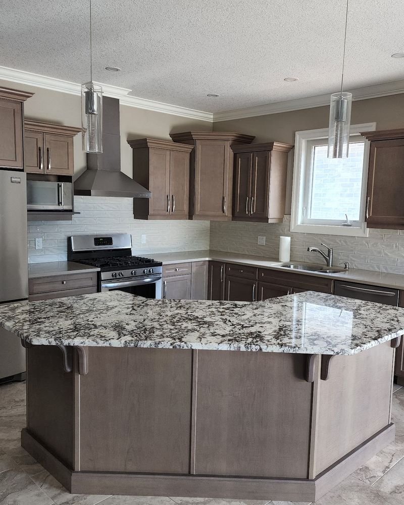 Kitchen with stained shaker cabinets, crown moulding and a granite-topped island, renovated by Elm Kitchen
