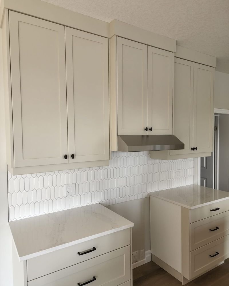 Ivory shaker cabinets with a picket tile backsplash and quartz countertops, installed by Elm Kitchen
