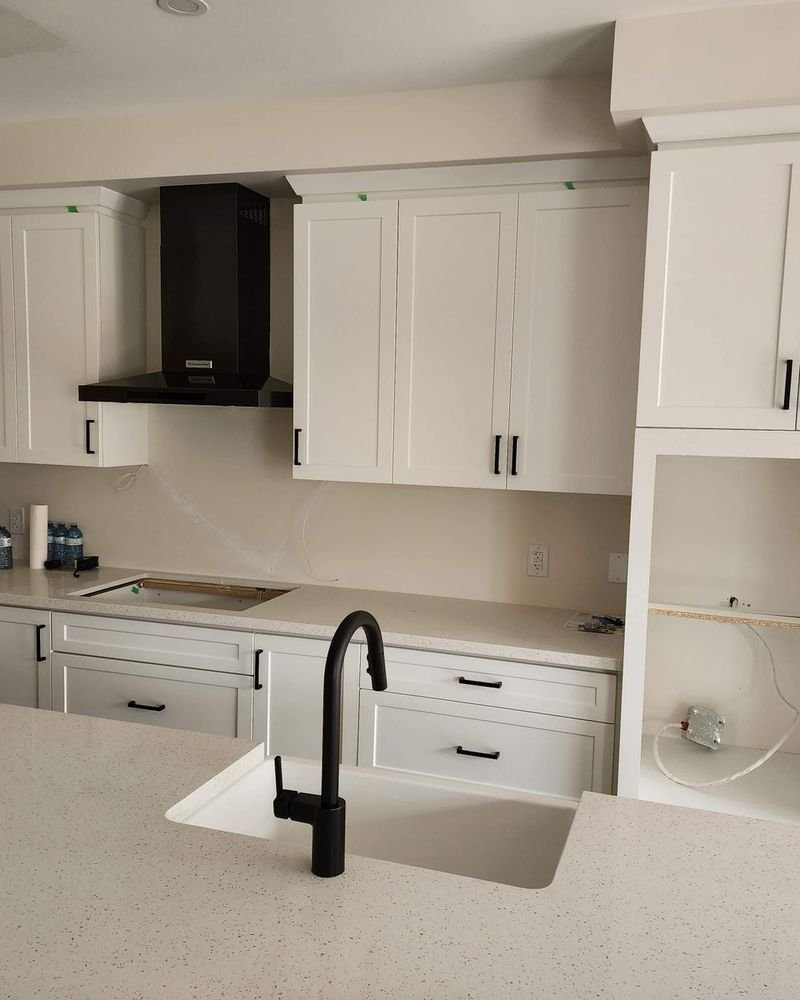 White shaker kitchen with quartz countertops and matte black fixtures, renovated by Elm Kitchen in St. Thomas