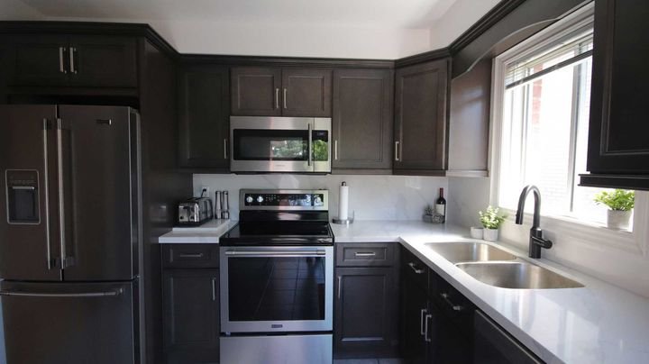 L-shaped kitchen with stainless appliances, London Grey cabinets by Canada Kitchens