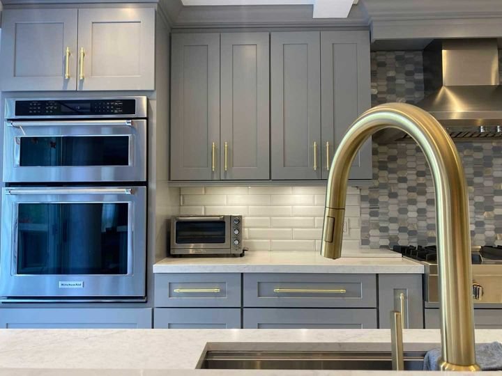 Sink run with a gold faucet, Shaker Grey cabinets by Canada Kitchens