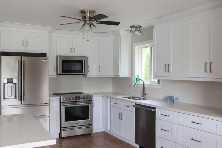 Kitchen corner with fridge and range, Shaker White cabinets by Canada Kitchens