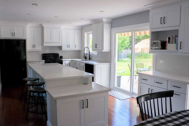 Island facing a patio door, Shaker White cabinets by Canada Kitchens