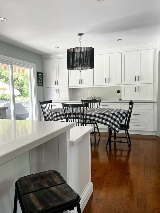Kitchen beside a dining table, Shaker White cabinets by Canada Kitchens